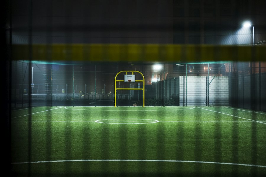 Projektører oplyser en lille sportsbane om aftenen